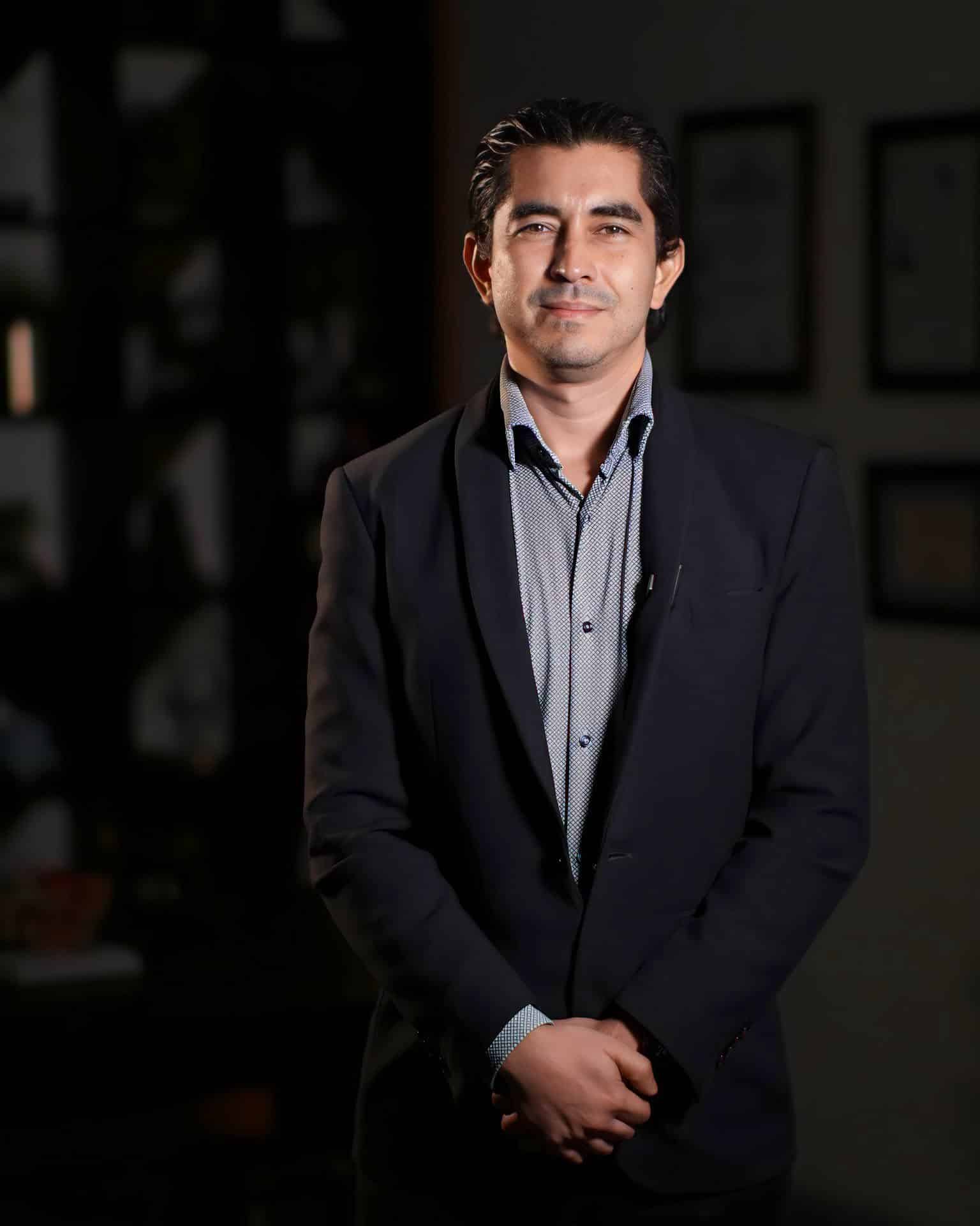 Dr. Héctor Togo con saco oscuro en su consultorio